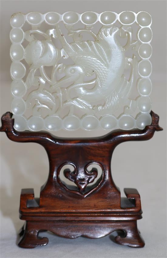 A Chinese pale celadon jade plaque, 18th / 19th century, 6.1cm, wood stand